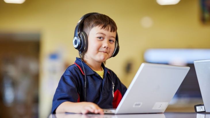 Student wearing headphones and using a computer
