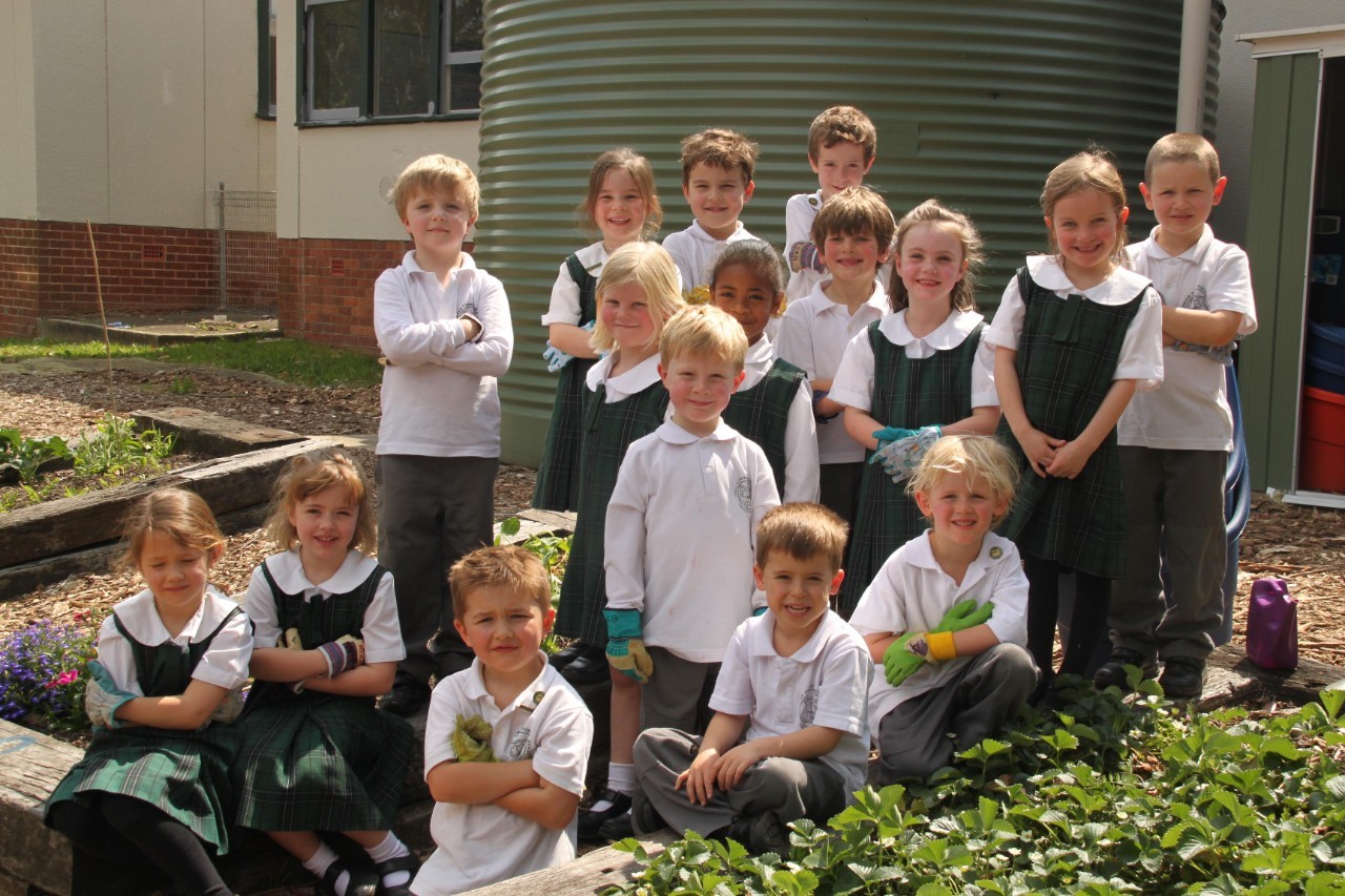 Students standing next to a vegetable patch